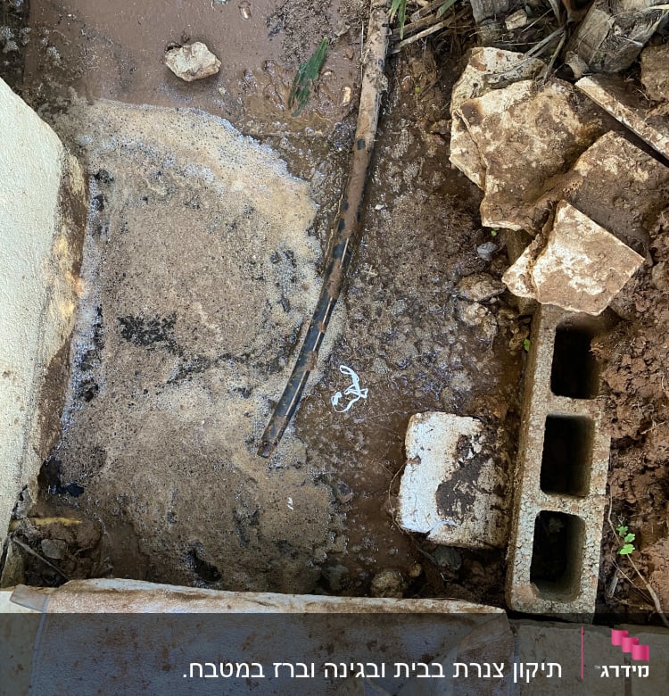 צינור שבור עם מים זורמים על האדמה